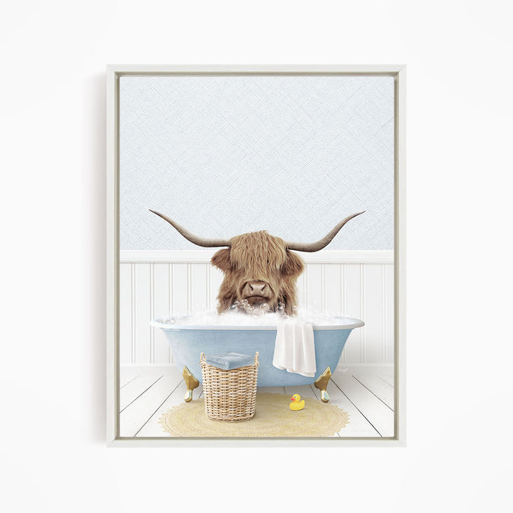 A brown cow with long horns is sitting in a blue bathtub filled with water, surrounded by a yellow rubber duck and a wicker basket.