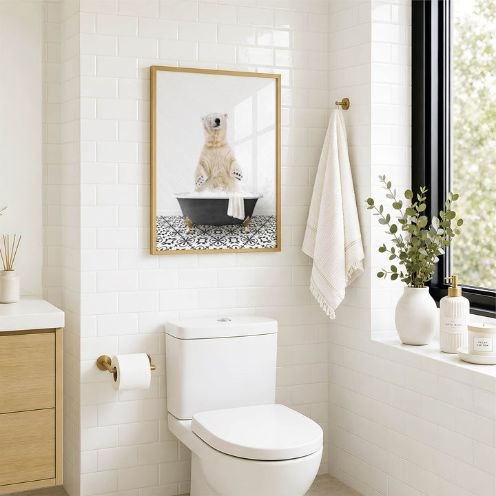 A bathroom with a white toilet, a framed picture of a polar bear sitting in a bathtub, and a window with greenery on the sill.