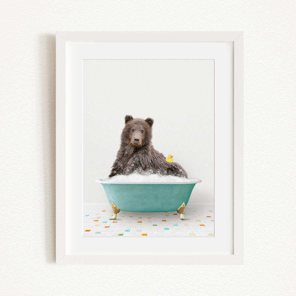 A brown bear sitting in a blue bathtub filled with bubbles, surrounded by small rubber duckies.