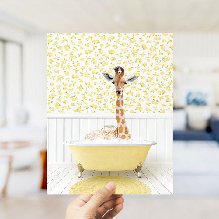 A giraffe sitting in a yellow bathtub filled with bubbles, surrounded by a yellow and white floral patterned wall.