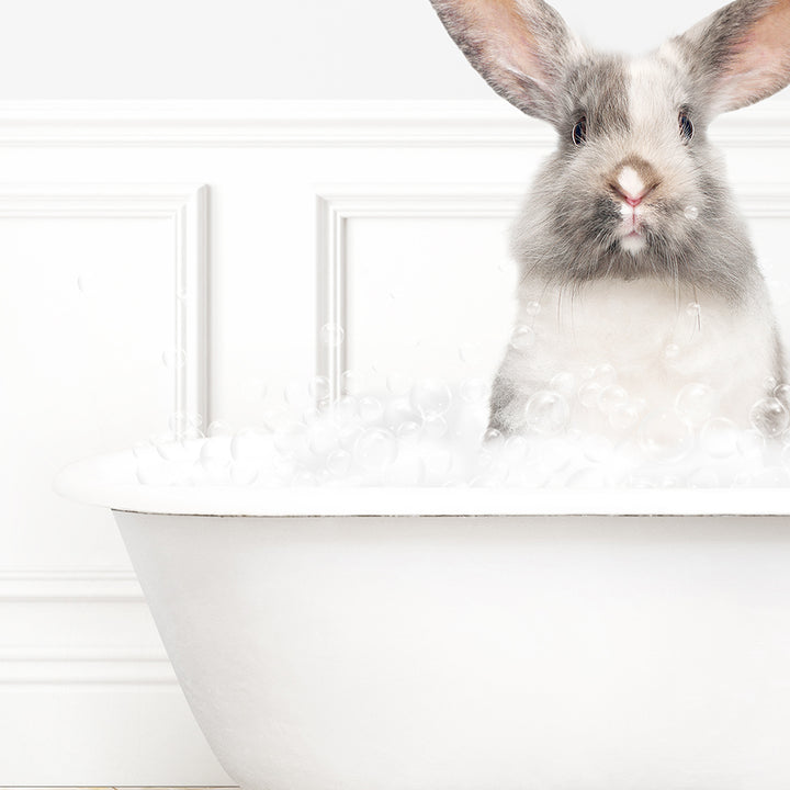 a rabbit is sitting in a bathtub with bubbles