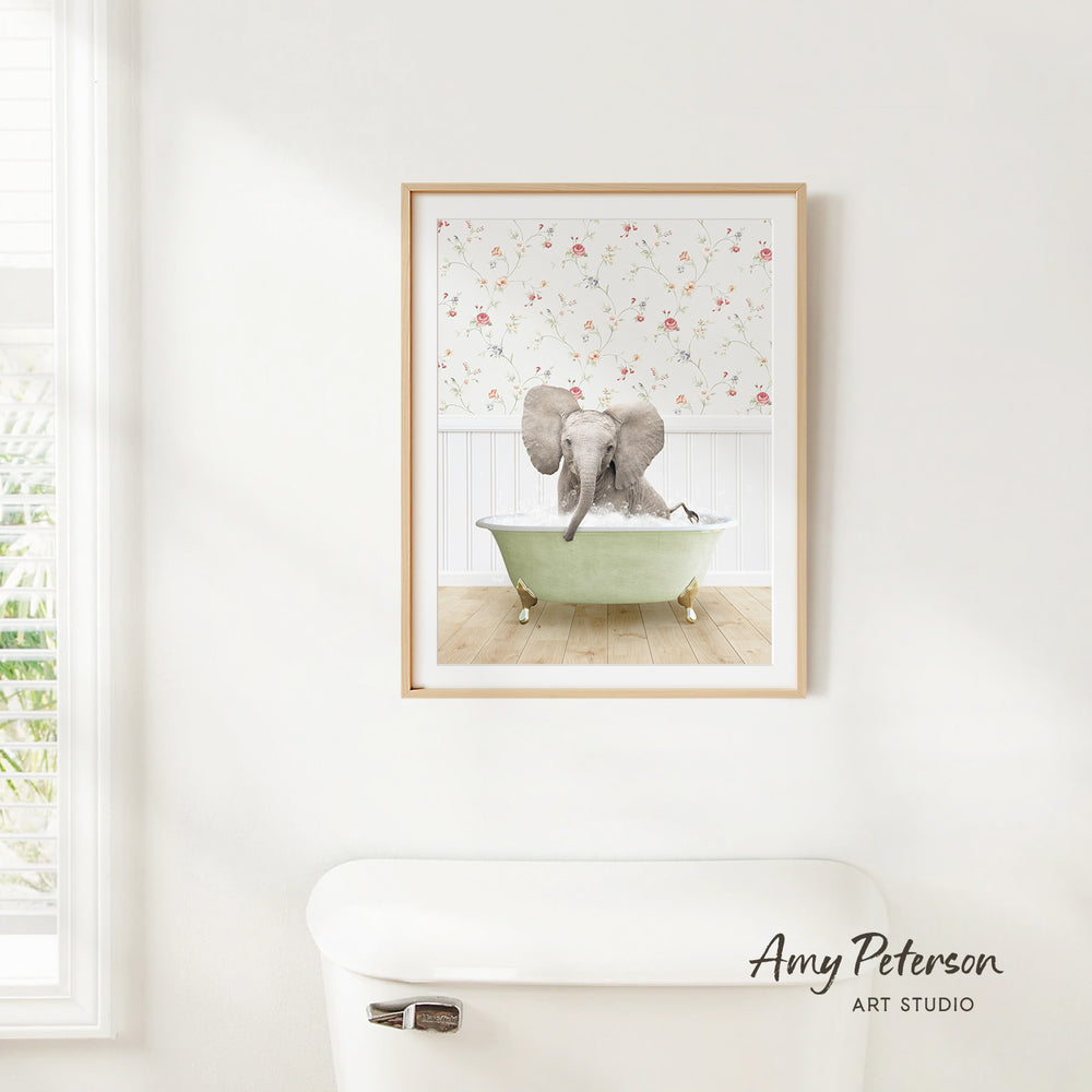 A framed image of an elephant sitting in a green bathtub, with a floral pattern on the wall behind it.