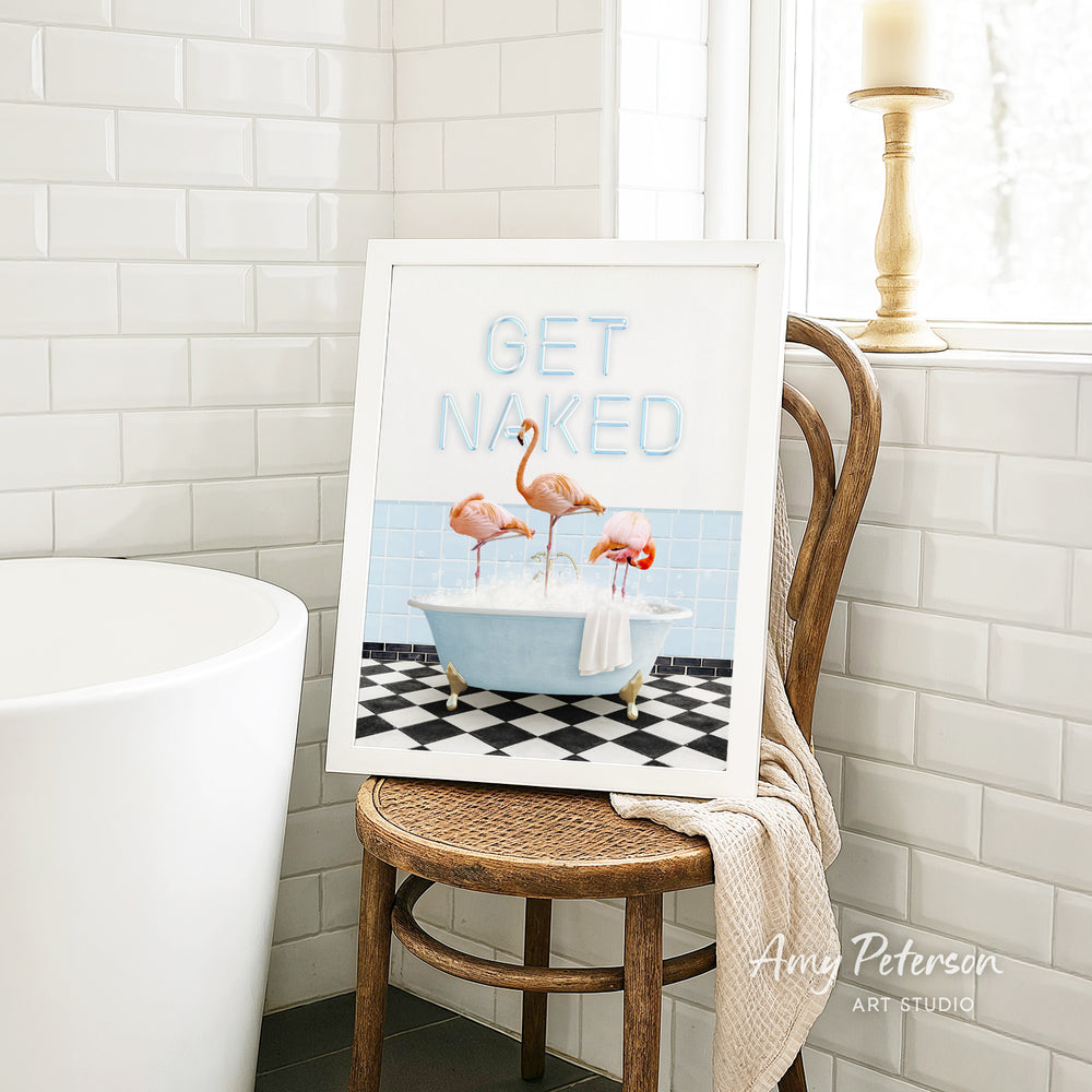 a framed print of a bathroom scene with a bathtub, a towel, and three flamingos.