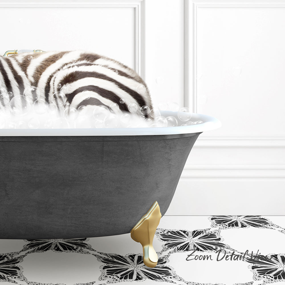 A zebra standing in a bathtub filled with bubbles, with a gold bathtub leg visible.