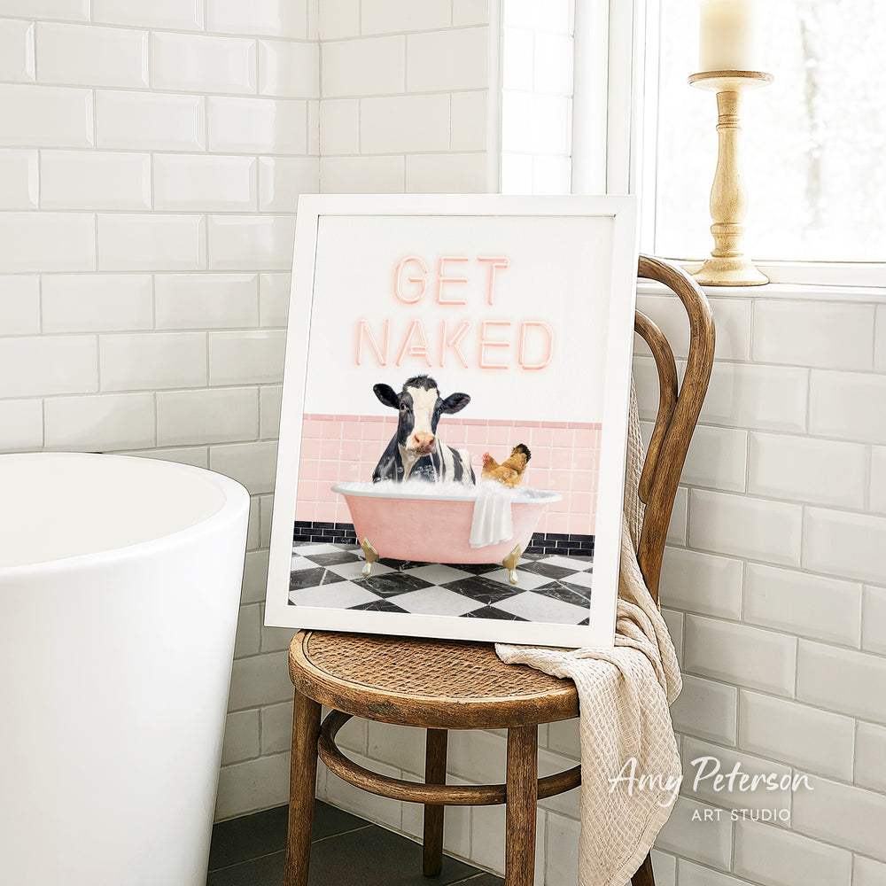 a framed print of a cow sitting in a bathtub, with the text "GET NAKED" written on it.