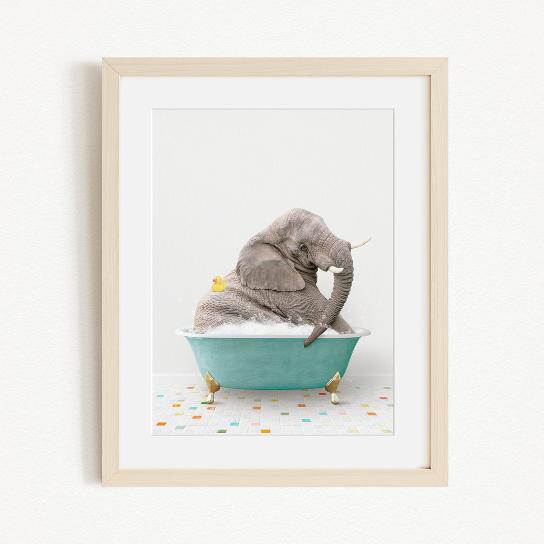 A gray elephant is sitting in a green bathtub filled with bubbles, surrounded by small yellow rubber ducks.