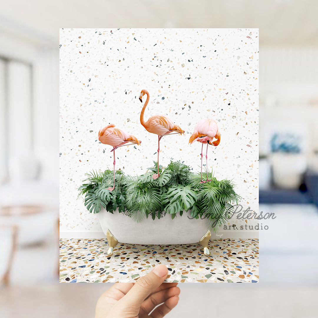 a hand holding a card with three flamingos in a planter