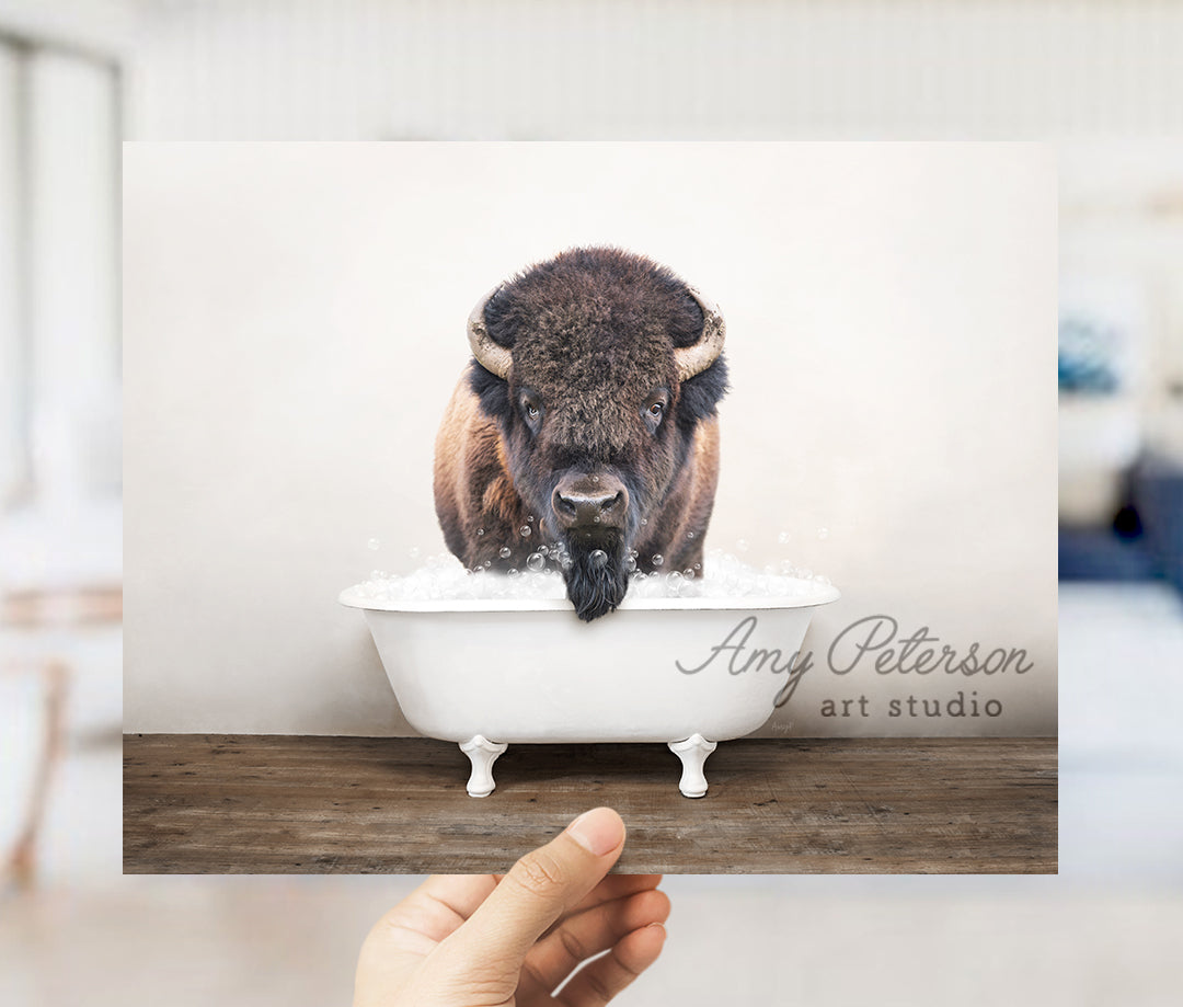 a person holding up a card with a picture of a bison in a bathtub