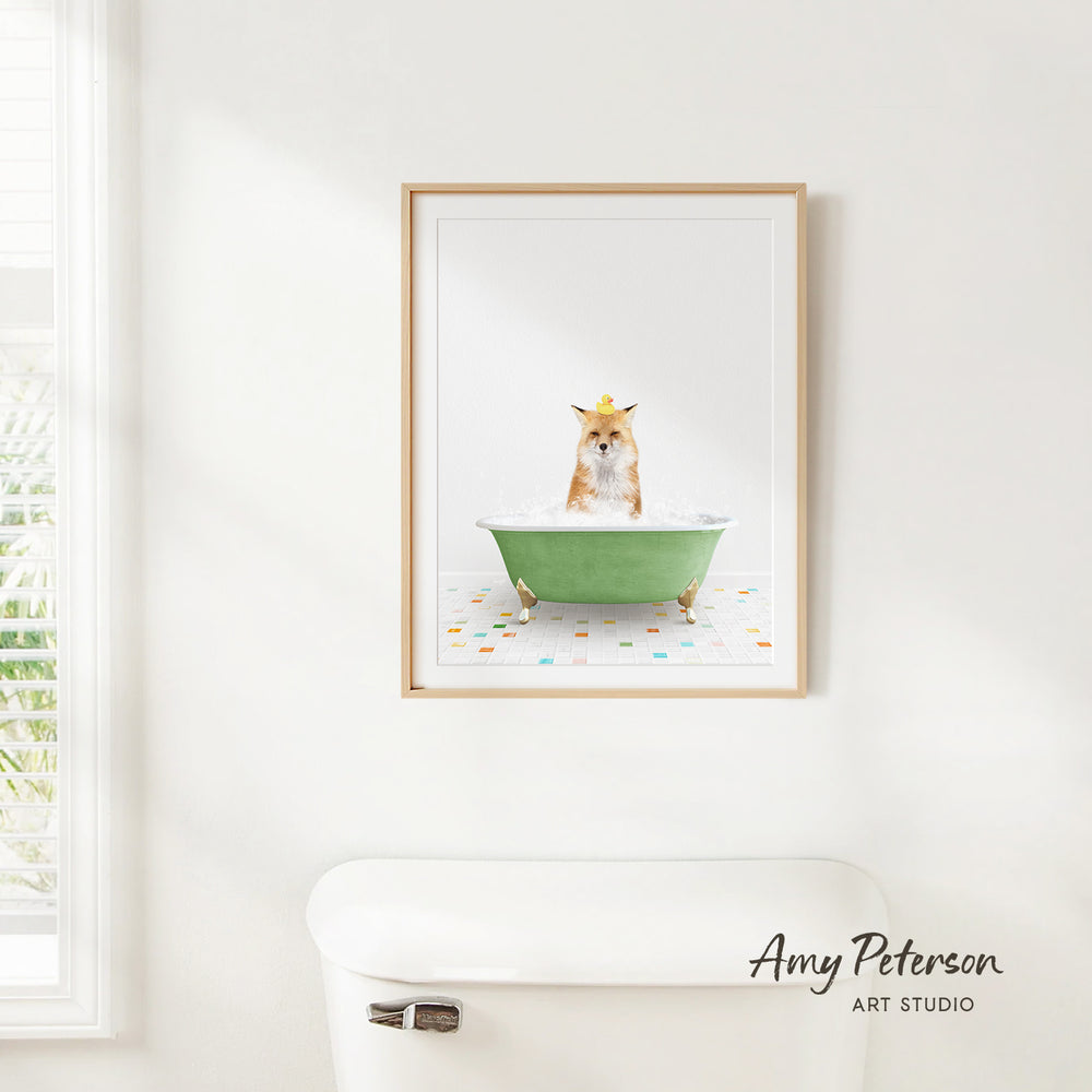 A framed image of a cat sitting in a green bathtub, with a towel on the floor and a window in the background.