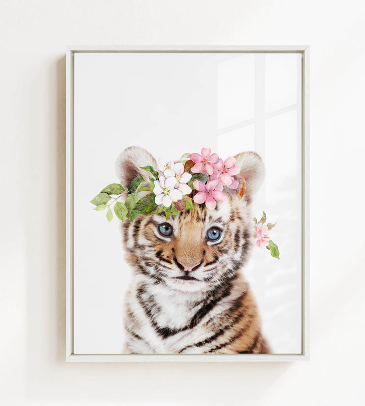 A young tiger cub wearing a floral crown of pink and white flowers.