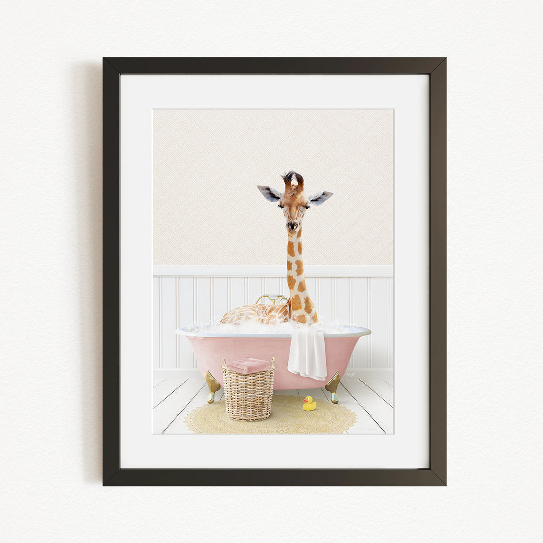 A giraffe standing in a pink bathtub filled with bubbles, surrounded by a yellow rubber duck and a basket.