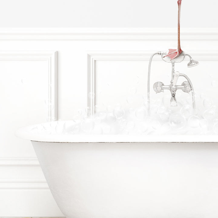 a white bath tub filled with water and a pink flamingo