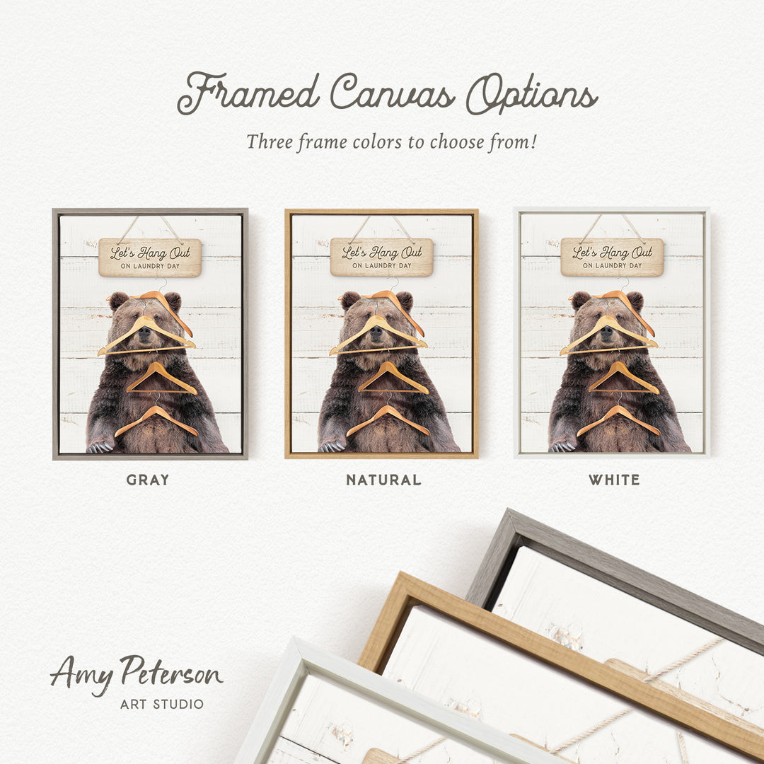 three framed canvas options, each featuring a bear wearing a hat and holding a pair of clothes hangers. The options include a gray, a natural, and a white frame.