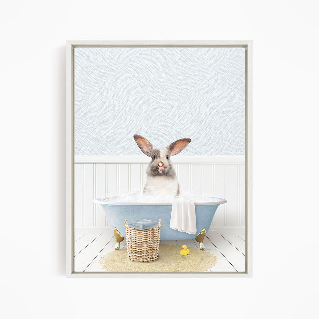 A white rabbit sitting in a blue bathtub filled with water, surrounded by a yellow rubber duck and a basket.