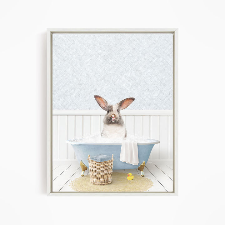 A white rabbit sitting in a blue bathtub filled with water, surrounded by a yellow rubber duck and a basket.