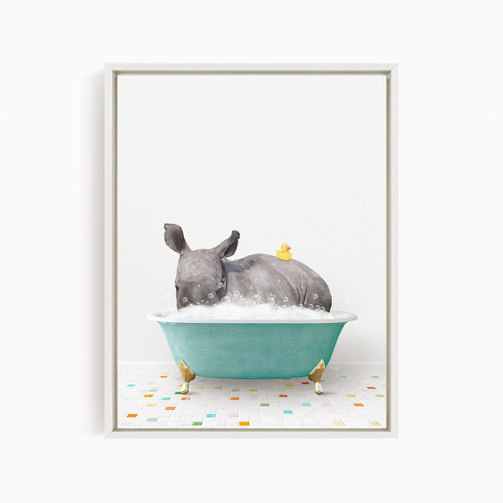 A rhinoceros is sitting in a blue bathtub filled with bubbles, with a yellow rubber duck floating on its back.