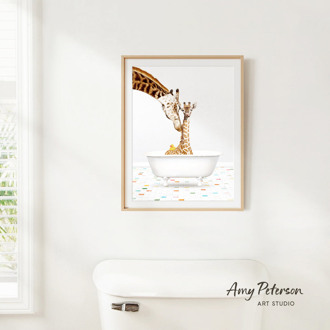 A framed painting of two giraffes in a white bathtub is hanging on a white wall.