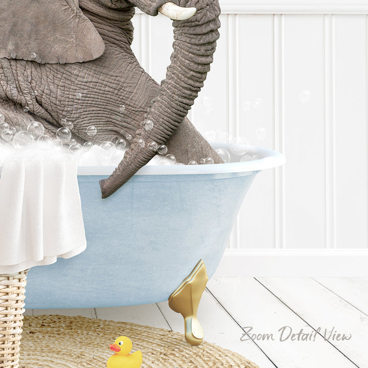 A large elephant is sitting in a blue bathtub filled with bubbles, surrounded by a yellow rubber duck and a white towel.