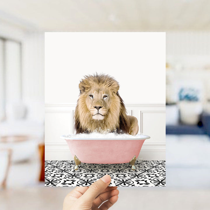 A lion sitting in a pink bathtub filled with bubbles, with a hand holding the image up to the viewer.