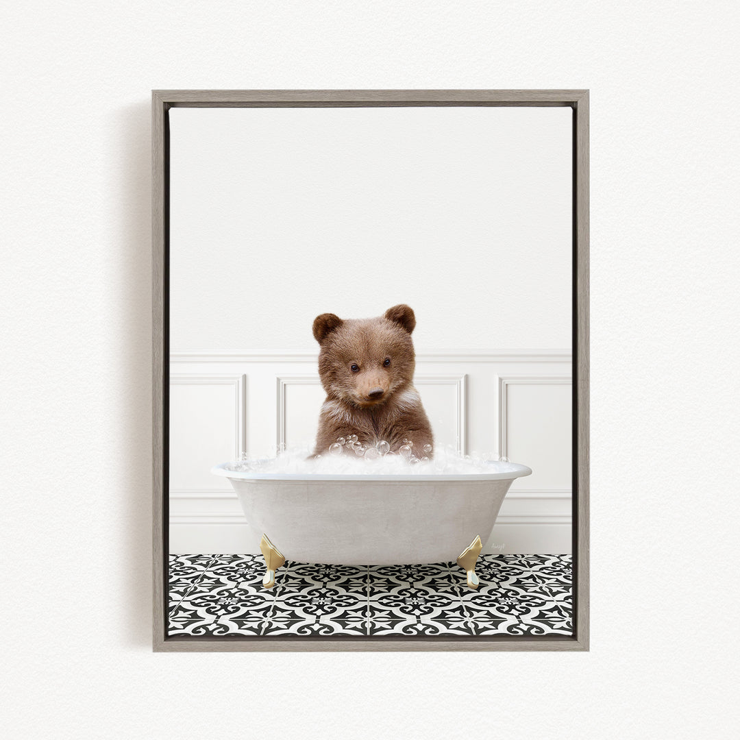 A brown bear sitting in a white bathtub filled with bubbles, looking directly at the camera.