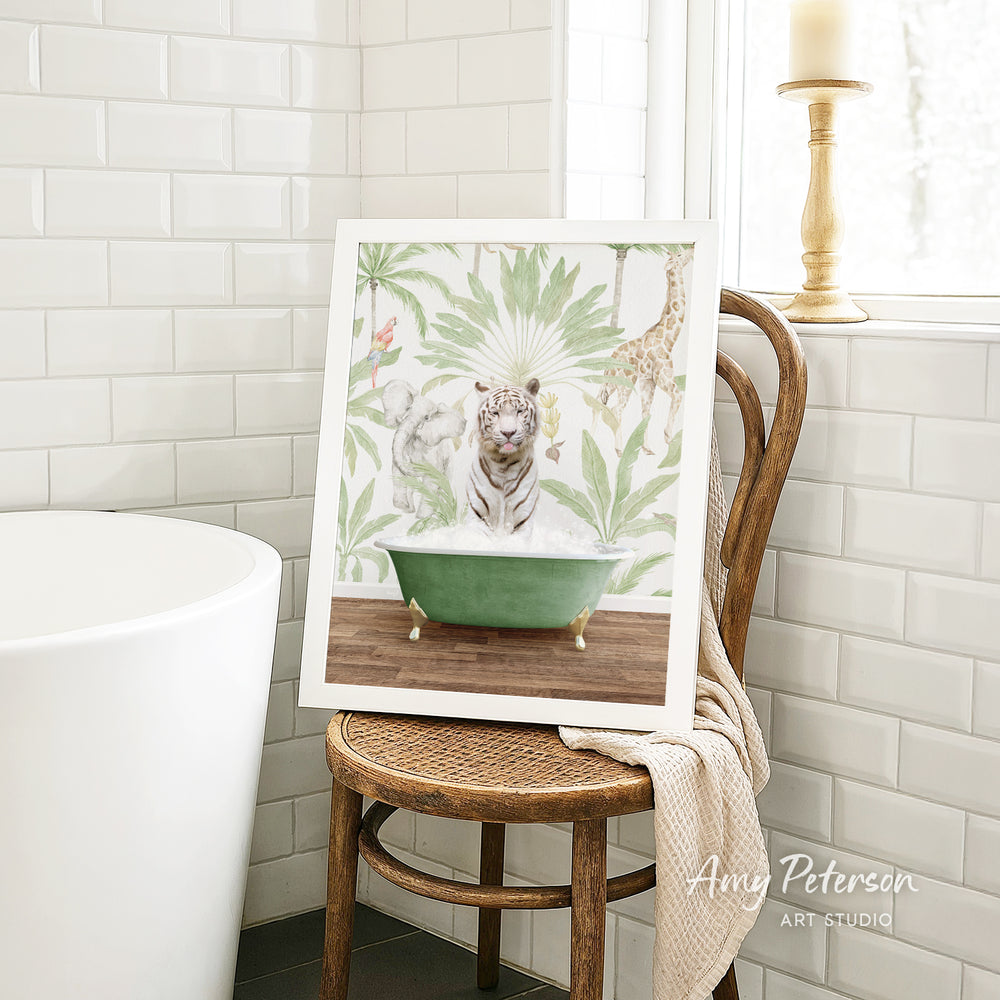 A framed print of a tiger sitting in a green bathtub is displayed on a wooden chair in a bathroom setting.