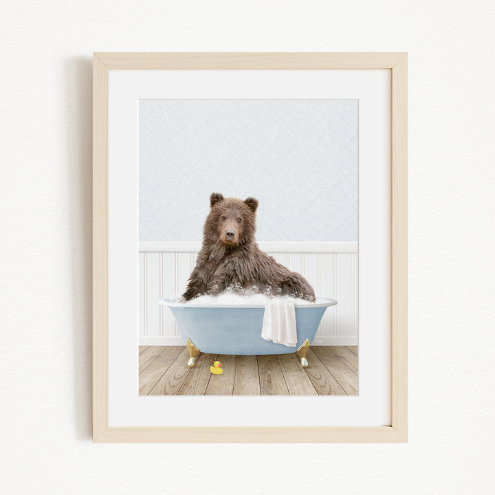 A brown bear sitting in a blue bathtub filled with water, surrounded by yellow rubber duckies.