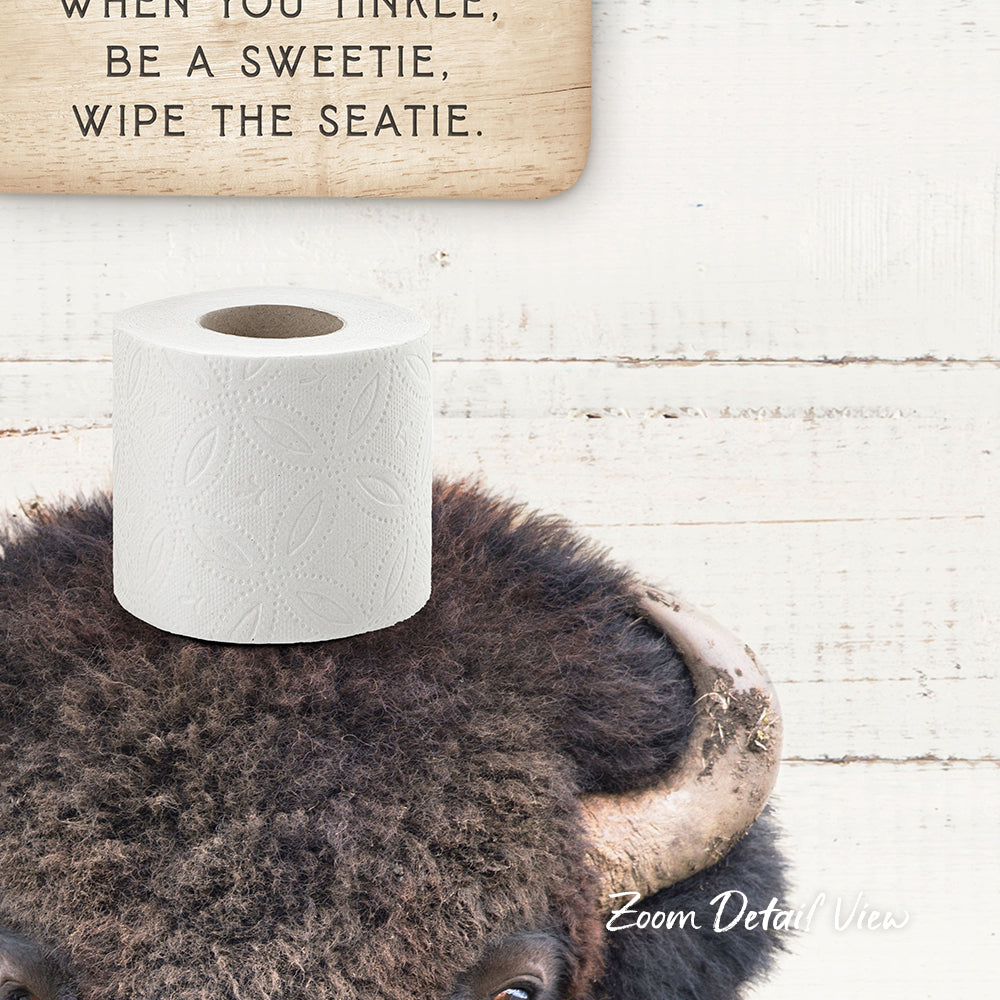 a close-up of a bison's head with a roll of toilet paper placed on top of it.