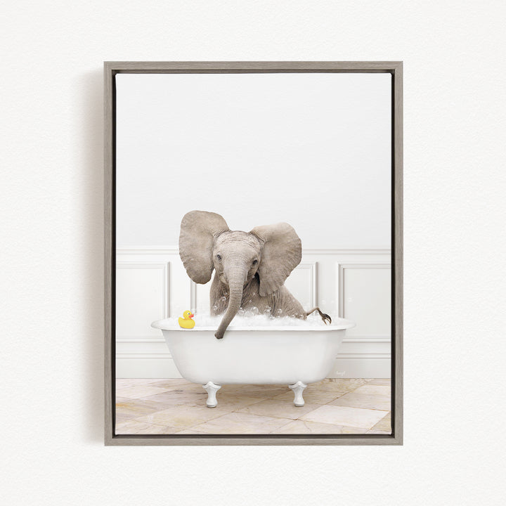 A gray elephant is sitting in a white bathtub, surrounded by a yellow rubber duck.