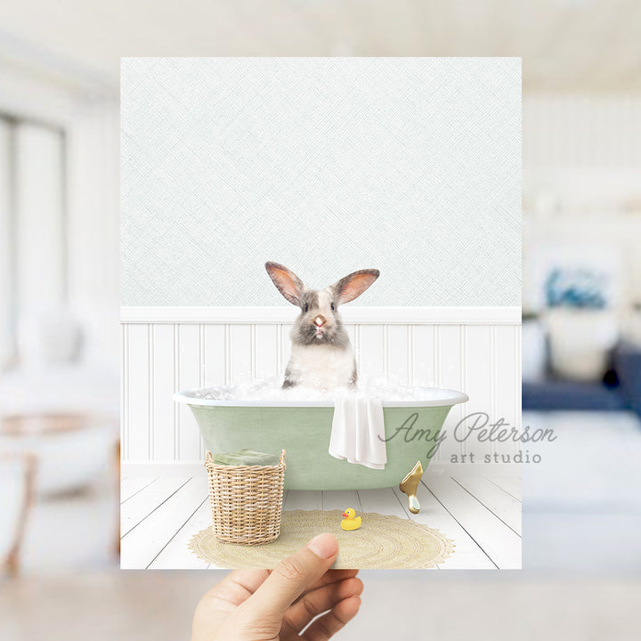 a person holding up a picture of a rabbit in a bathtub