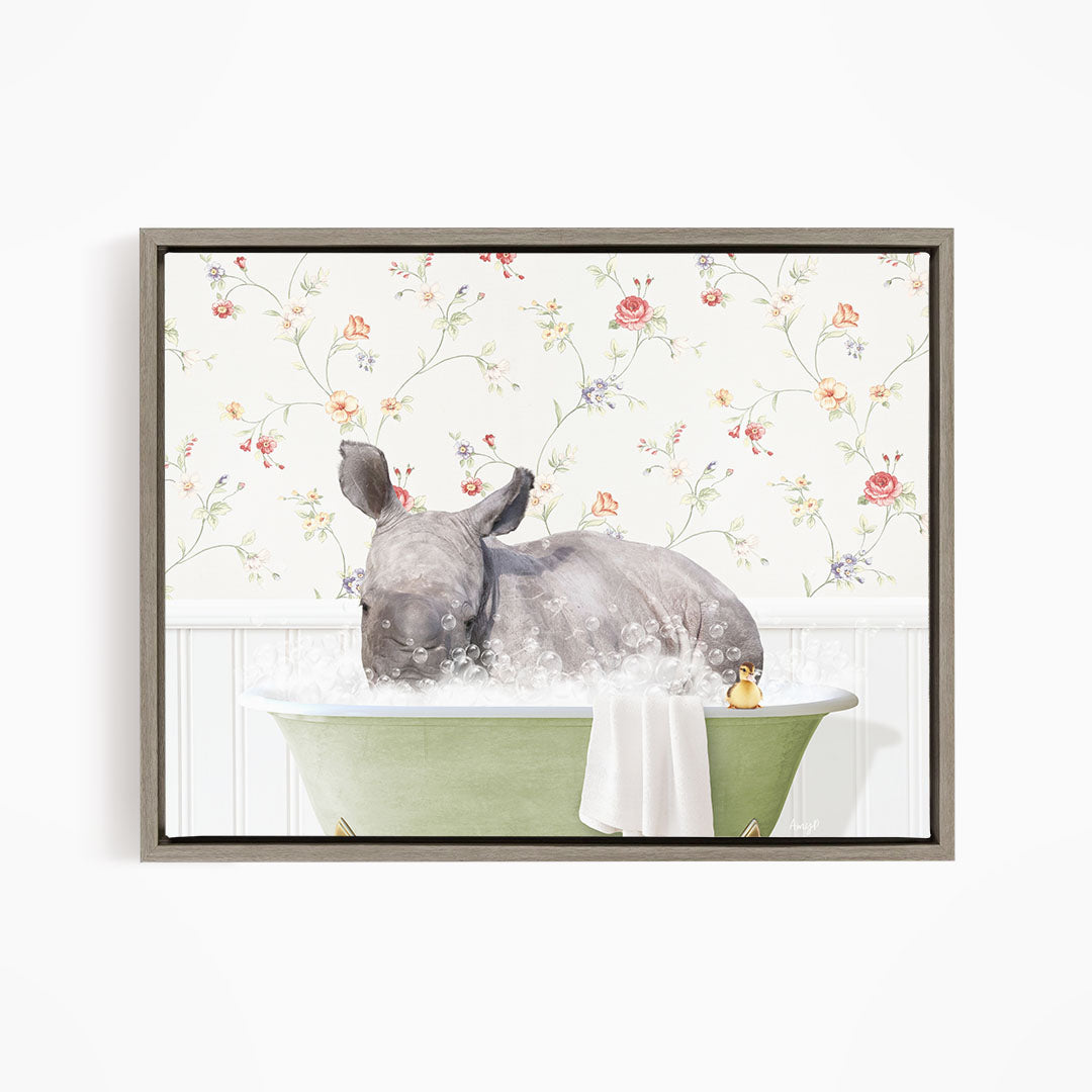 A rhinoceros is sitting in a green bathtub filled with bubbles, surrounded by a floral wallpaper.
