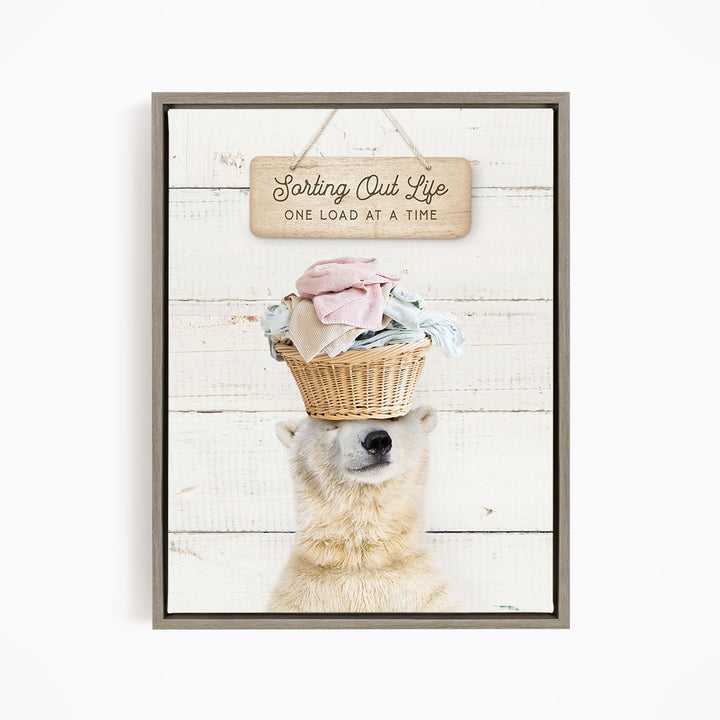 A polar bear balancing a basket of laundry on its head, with a sign above that reads "Sorting Out Life One Load at a Time".
