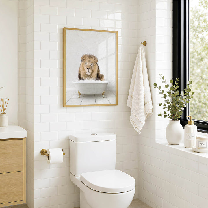 A framed image of a lion sitting in a bathtub is displayed on the wall above a white toilet in a bathroom.