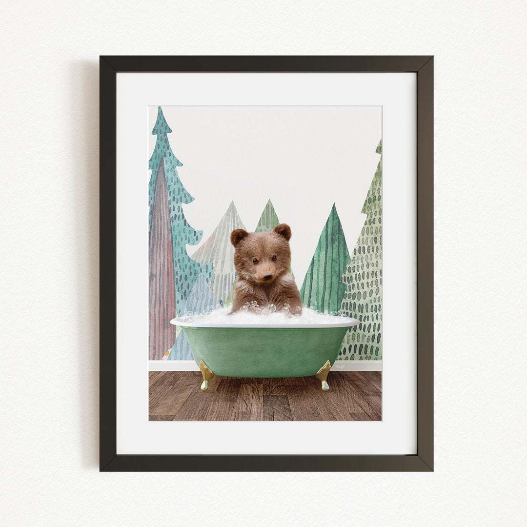 A small brown bear is sitting in a green bathtub, surrounded by a forest scene with trees and a snowy landscape.