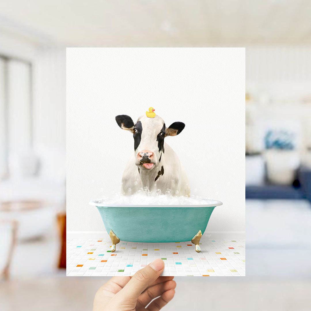 A cow is sitting in a bathtub filled with bubbles, with a rubber duck perched on its head.