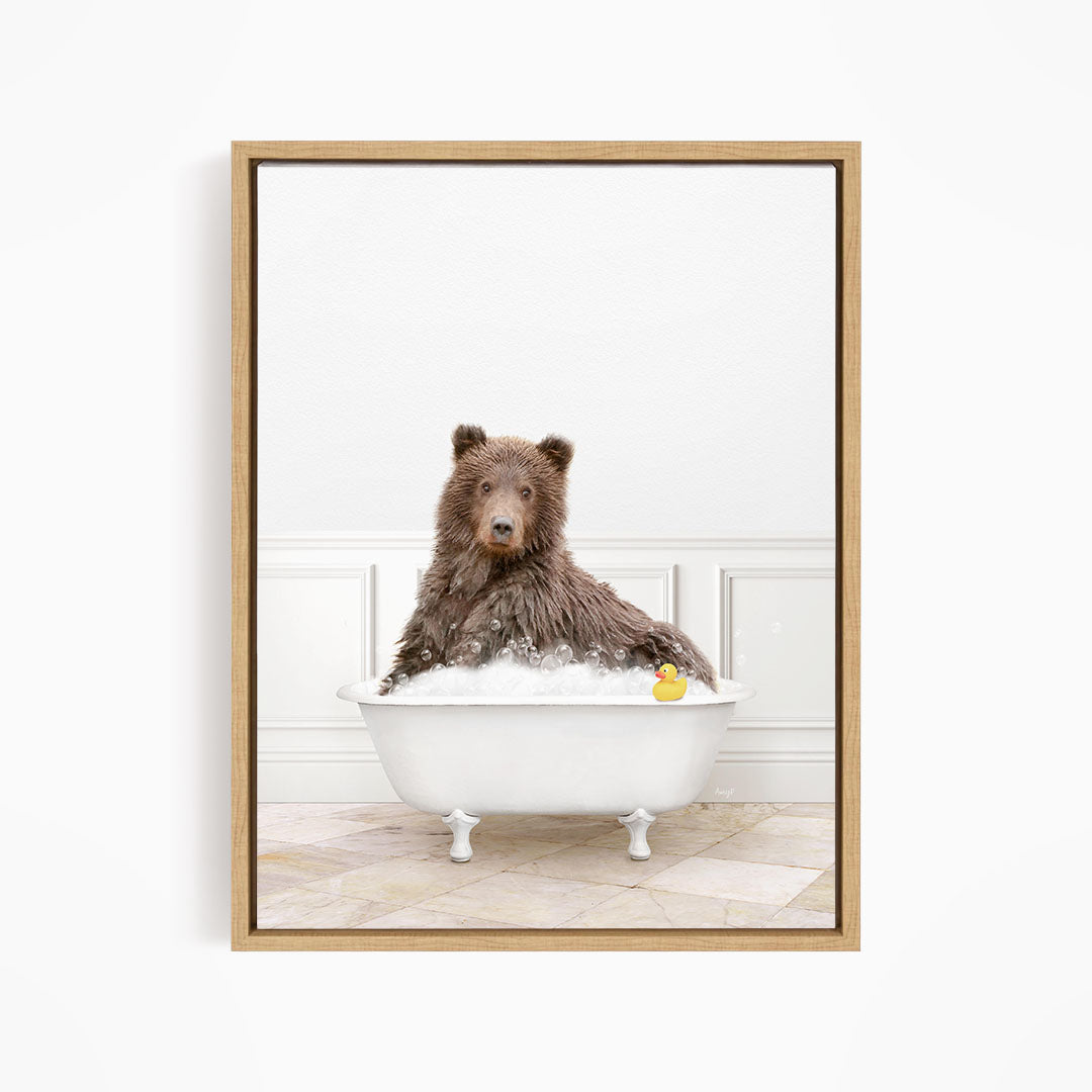 A brown bear sitting in a white bathtub, with a rubber duck floating in the water.