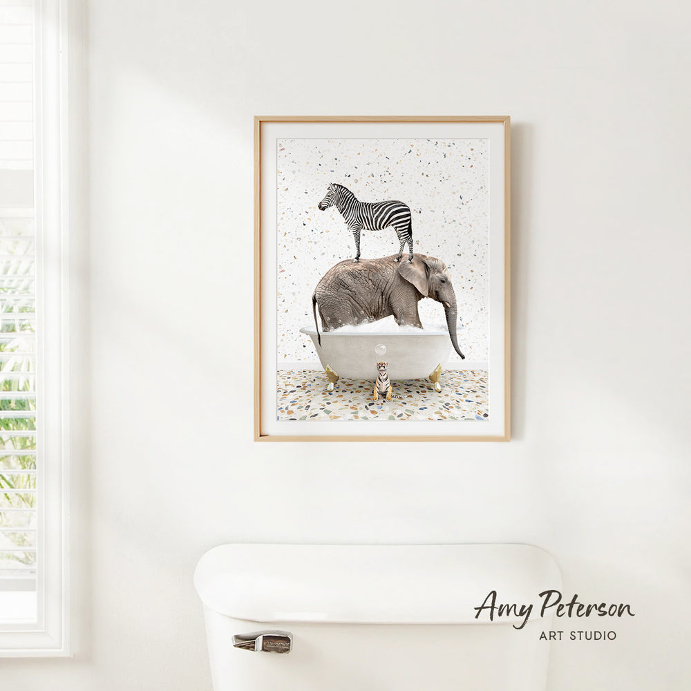 A framed print of a zebra standing on an elephant's back is hanging on a white wall above a white toilet.