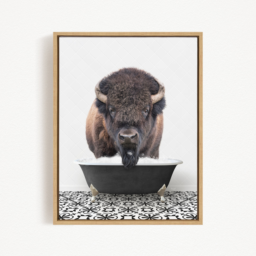 A buffalo with a long beard is standing in a black tub filled with water, looking directly at the camera.