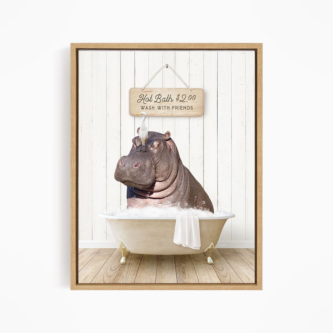 A framed image depicting a hippopotamus sitting in a bathtub, with a sign above it that reads "Hot Bath $2.00 WASH WITH FRIENDS".