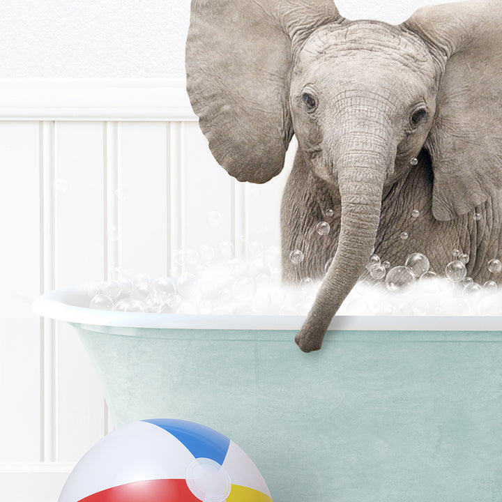 an elephant in a bathtub with bubbles and a beach ball