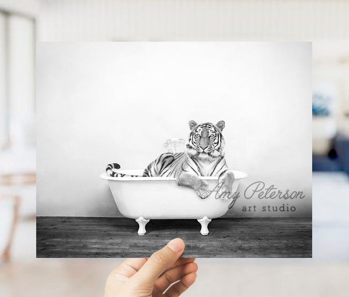 a person holding up a black and white photo of a tiger in a bathtub