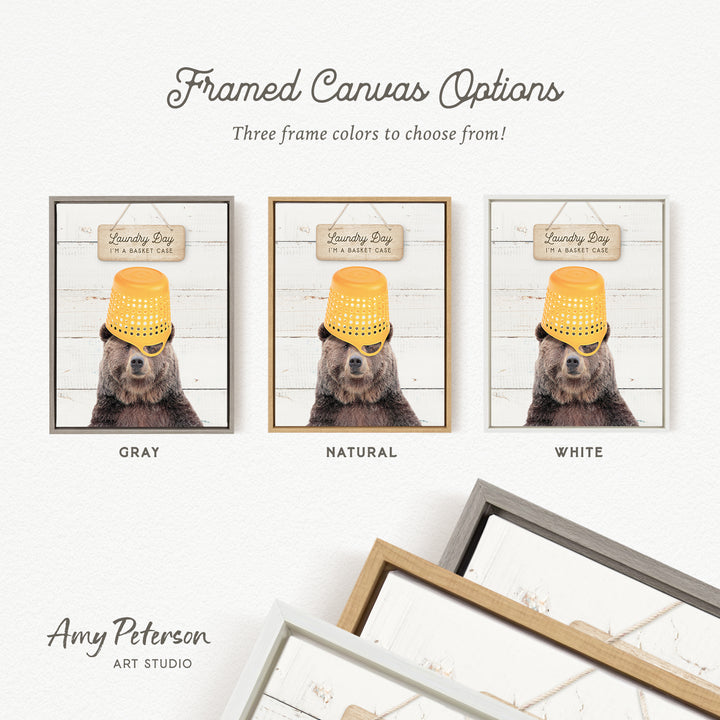 three framed canvas options featuring a bear wearing a yellow bucket hat. The bear is positioned in front of a sign that reads "Laundry Day I'm a basket case". The options include a gray, natural, and white frame.
