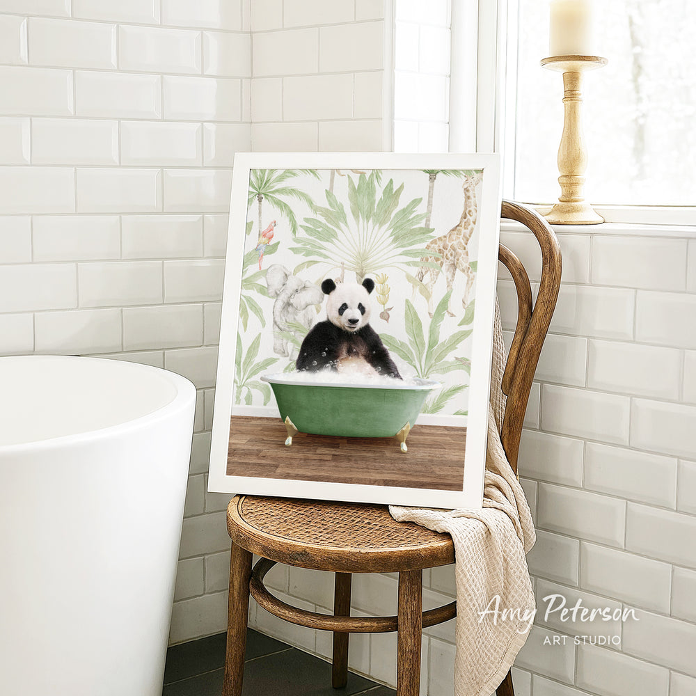 A framed image of a panda sitting in a green bathtub is displayed on a wooden chair in a bathroom setting.