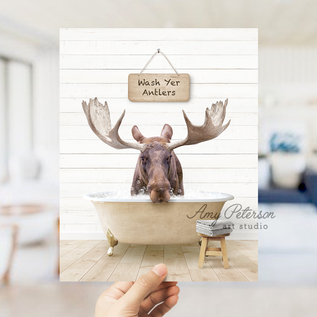 a hand holding up a card with a moose head in a bathtub