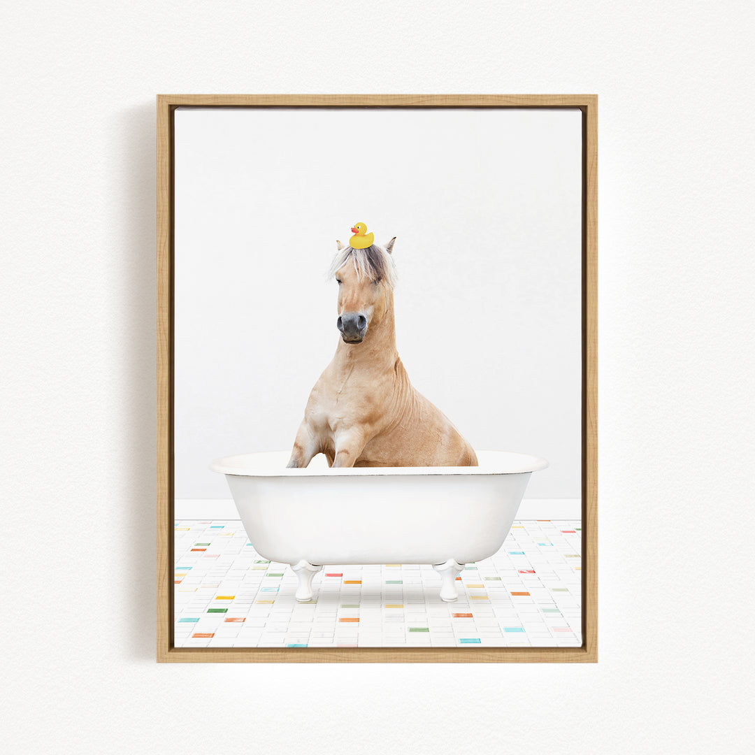 A light brown horse is sitting in a white bathtub, with a yellow rubber duck perched on its head.