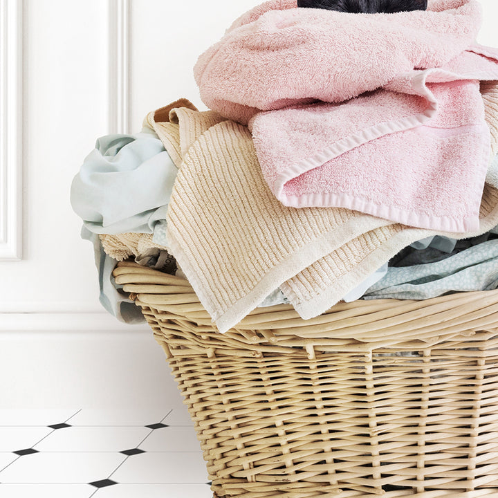 a wicker basket filled with a pile of clothes