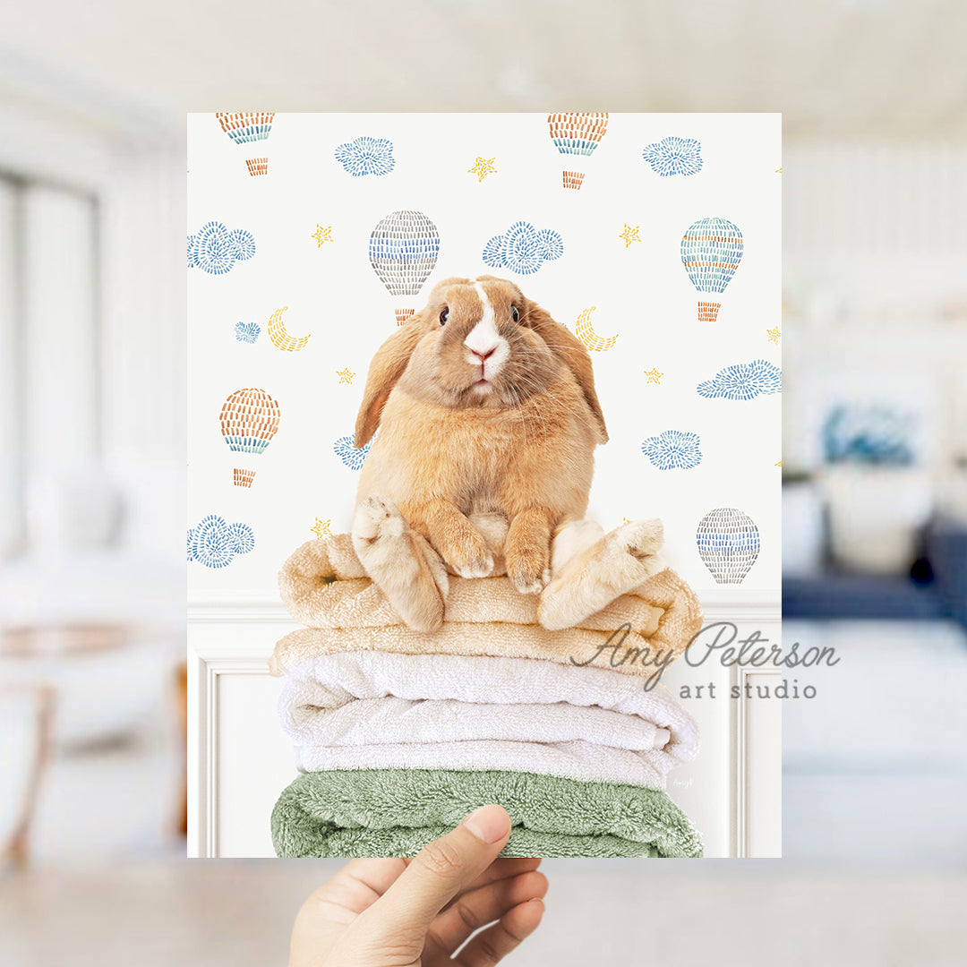 a rabbit sitting on top of a stack of towels