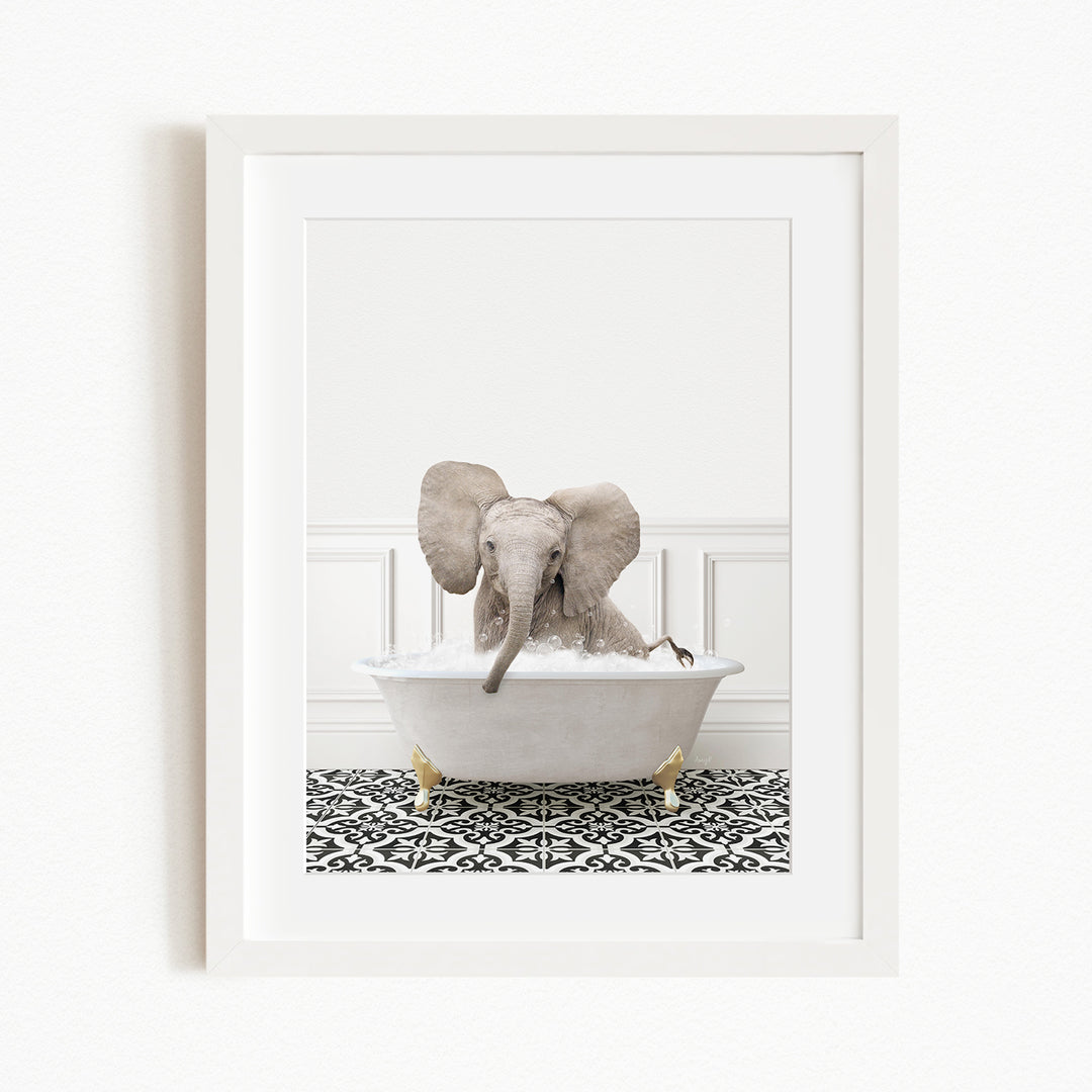 A baby elephant sitting in a white bathtub filled with water, surrounded by a black and white patterned rug.