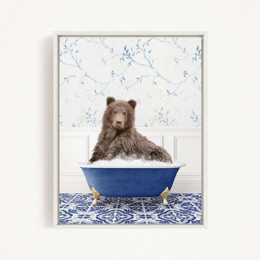 A brown bear sitting in a blue bathtub filled with bubbles, surrounded by a blue and white patterned rug and a floral wallpaper.