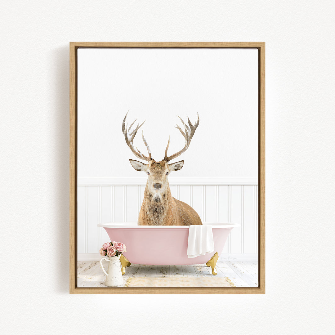 A deer with antlers sits in a pink bathtub, surrounded by pink flowers and a white vase.