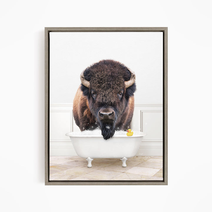 A buffalo with a long beard is sitting in a white bathtub, with a rubber duck floating in the water.